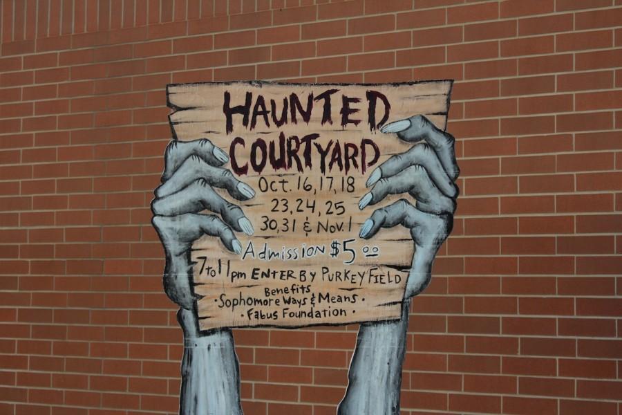 Handcrafted signs welcome the public to the Haunted Courtyard with open arms.