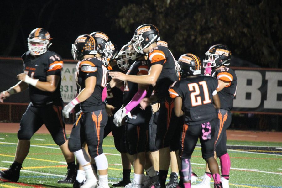 Hawks congratulate each other after a touchdown during their game against Canon Mac on Friday, Oct. 13.