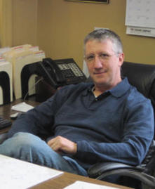 Thomas Dunkel, aka Shingle Shaker, sits at his desk at Dunkel Roofing in Punxsutawney.