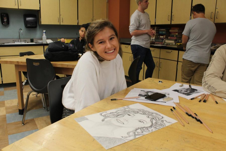 SWIMMING IN ART, senior art student Alexa Will takes a breather to smile for the camera.