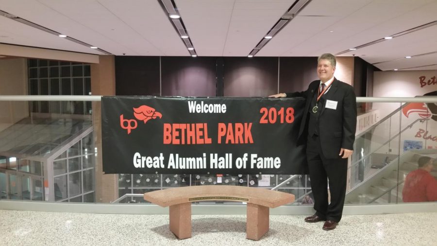 2018 inductee Robert Computer Bob Emmelkamp poses with the Great Alumni Hall of Fame banner.