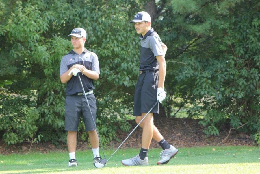 LOOKING IN THE DISTANCE, junior Parker Loera and sophomore Zack Sackett watch their drives after teeing off. 