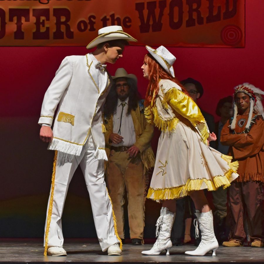 Collin McCormick as Frank Butler and Katelyn Marcovecchio as Annie Oakley duel on stage.