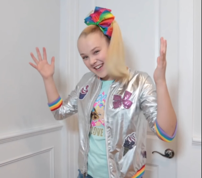 JoJo Siwa singing and smiling during one of her music videos. 
