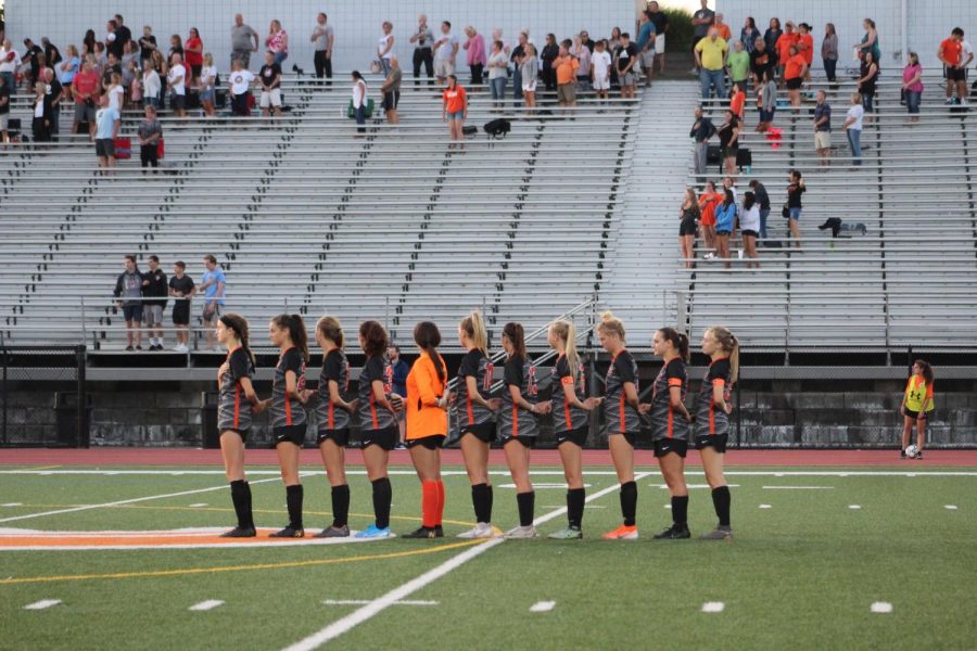 Lady Hawks stand in line during the National Anthem before their game against Peters on Wednesday, Sept. 4.