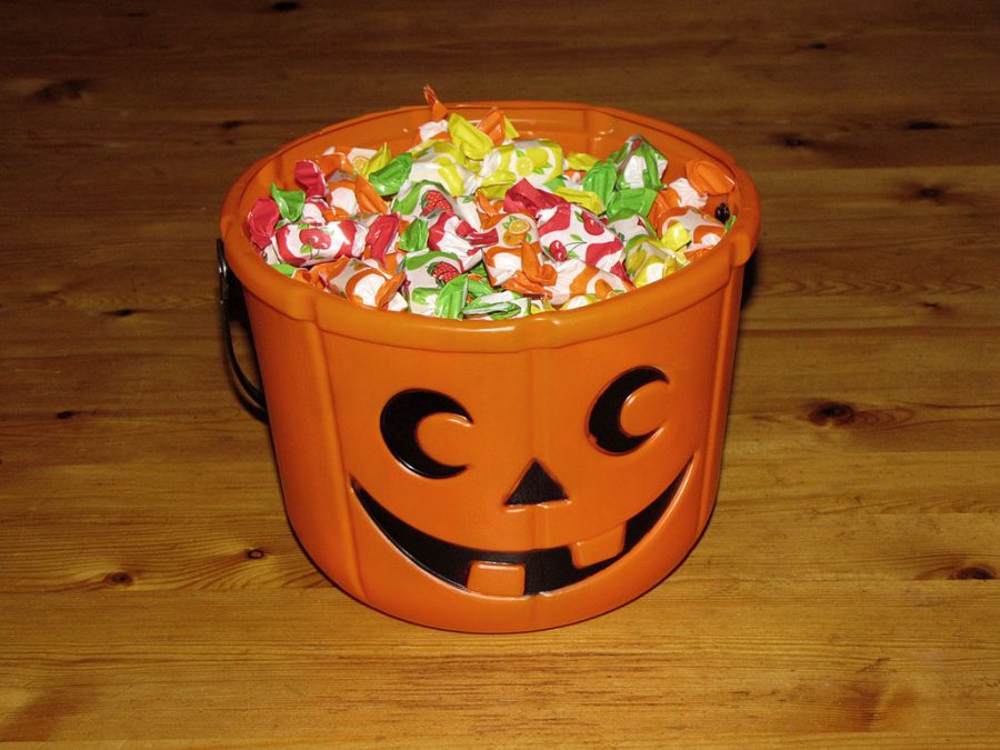 A Halloween candy bucket filled with candy.