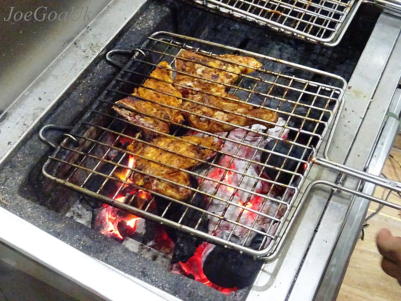 Chicken cooking on the grill. Chicken is an example of a high protein food. 