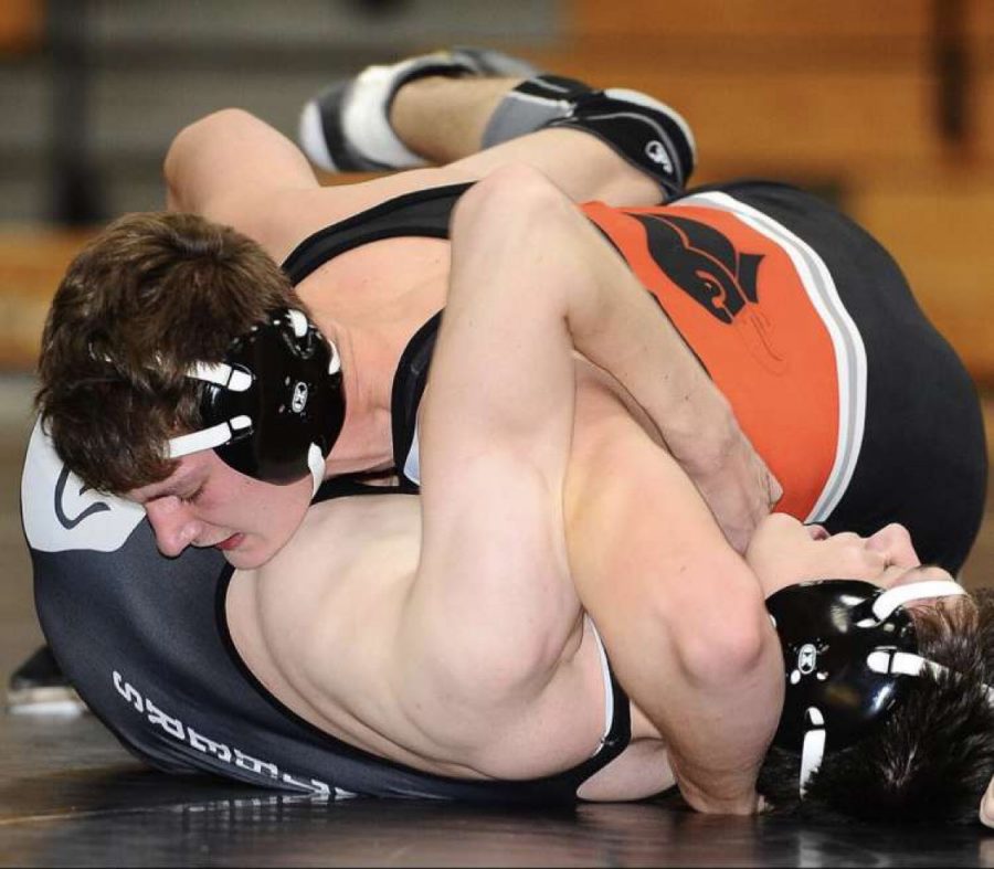 Senior Vinny Riepole pins his opponent during a match.