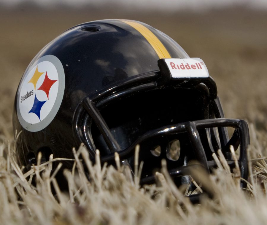 Stylized image of a Pittsburgh Steelers helmet sitting on a grass field.
