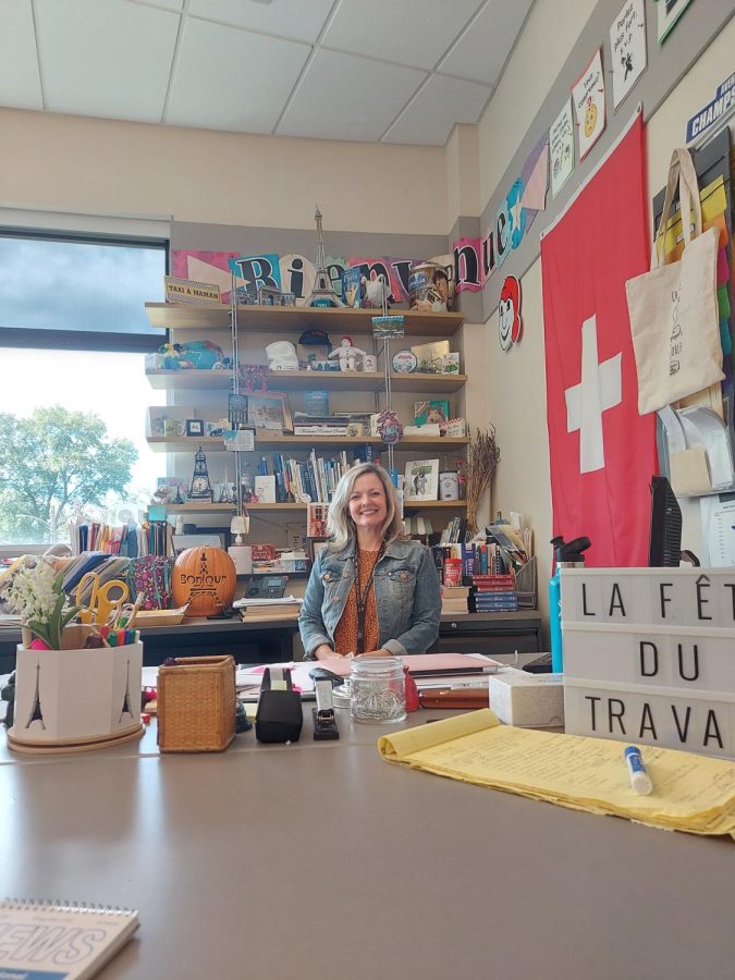 Madame Smith is all smiles behind her teachers desk.