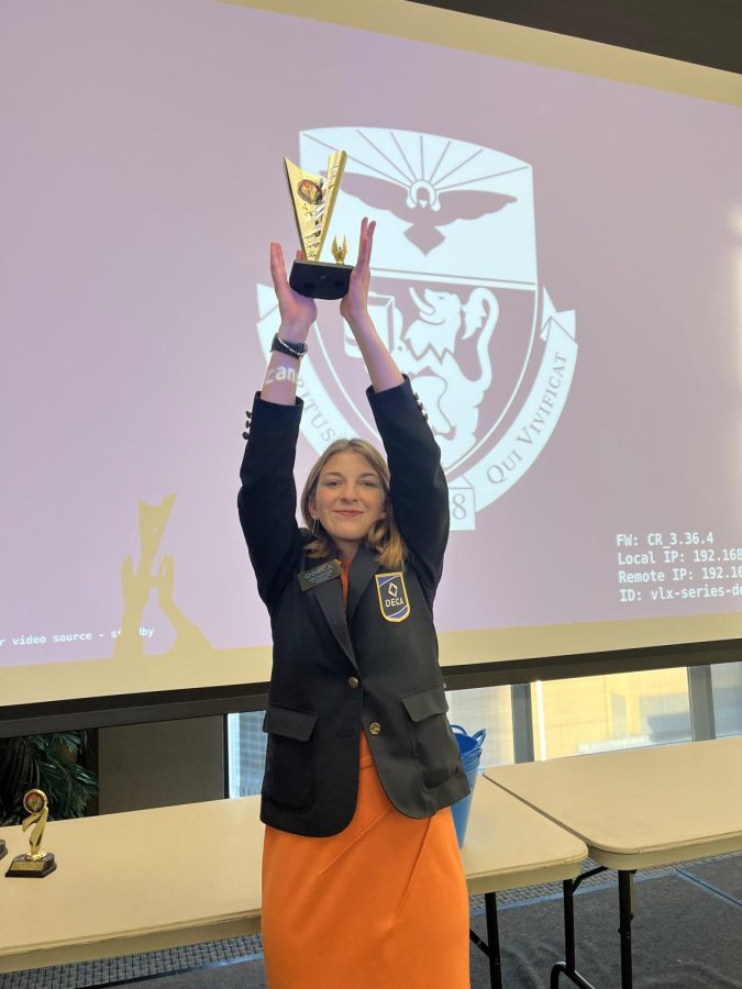 Lexi+Dorfner+proudly+holds+up+her+first+place+trophy+for+Human+Resources+Management.