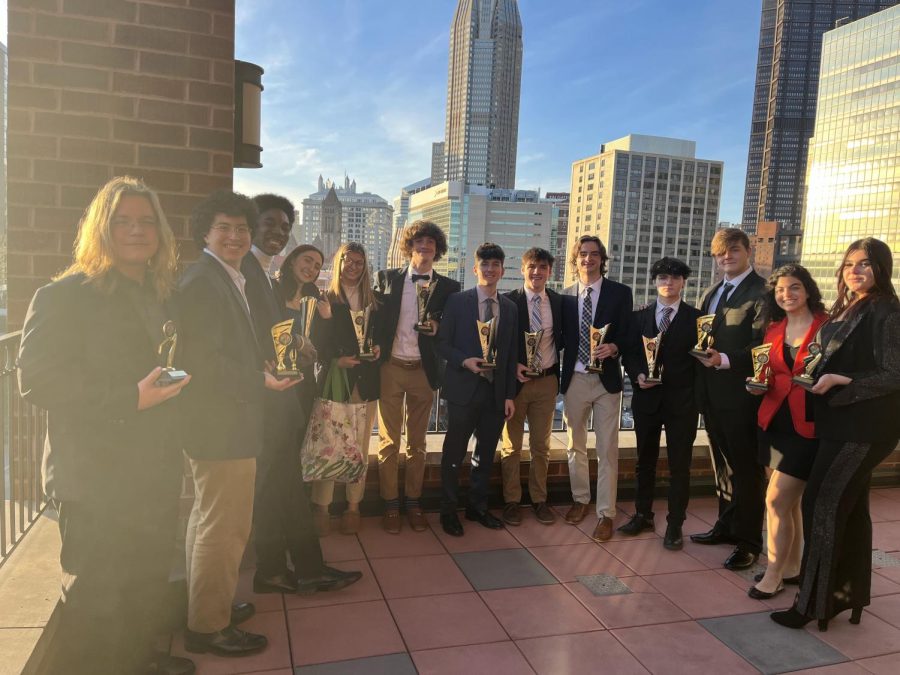 Students show off their trophies at the DECA Districts competition at Duquesne University.