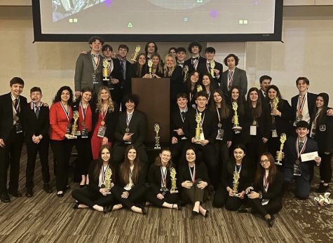DECA state conference winners pose for a picture with their trophies.