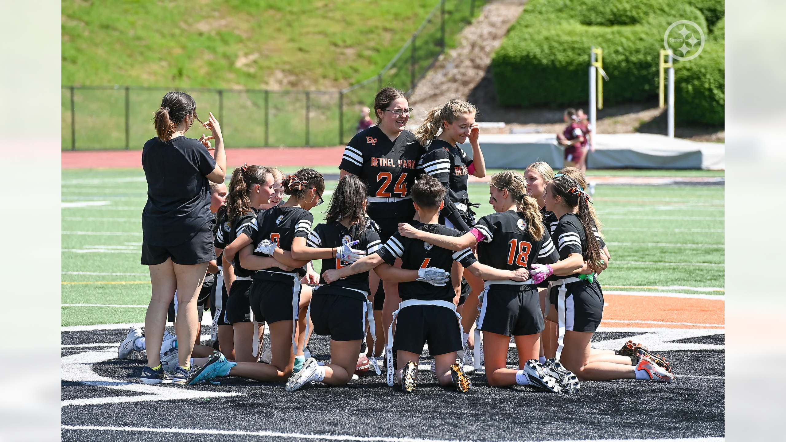 The 2025 girls flag football team huddles up before a game.